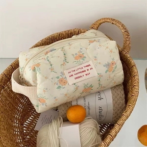 Floral quilted cotton makeup bag with cream base and soft yellow floral pattern in a basket