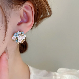 Detail of blue and white ceramic flower cluster earrings with golden center beads