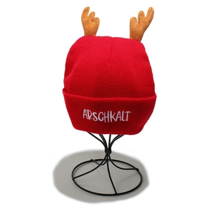 Detail of red knit hat featuring plush reindeer antlers and white embroidered lettering