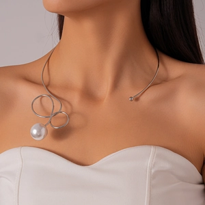 Macro shot of silver metal collar featuring a spiral twist and a glossy white pearl pendant