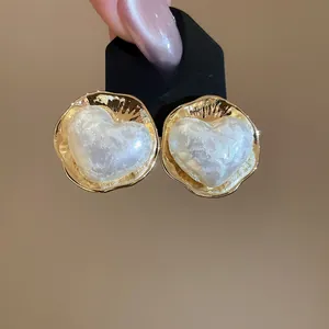 Dettaglio orecchino a cuore placcato oro 16K con perla su scheda espositiva nera