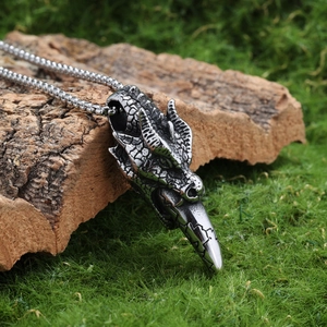 Gothic dragon head pendant necklace in antique silver finish on natural wood moss
