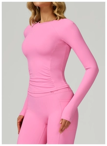 Détail du haut de yoga rose avec fronces latérales et poignets passe-pouce