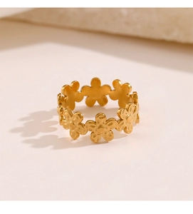 Close-up of golden adjustable floral ring featuring brushed metal finish and five-petal design
