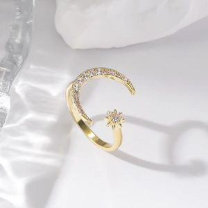 Detailed macro view of the gold moon and star ring featuring sparkling zircon gemstones