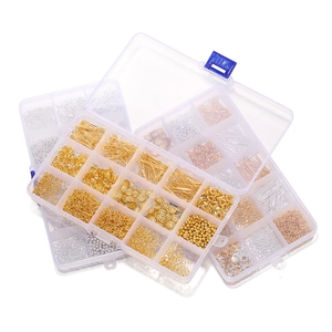 Macro view of gold and silver jewelry making kit in a multi-grid plastic organizer box
