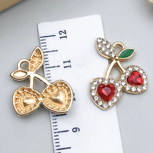 Macro view of cherry pendants with red heart stones and back texture against a ruler