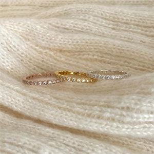 Detailed macro view of three stacked eternity rings in gold, rose gold and silver colors