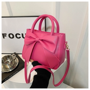 Detail of rose pink mini box bag with large 3D bow and double round handles