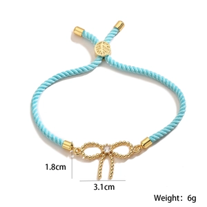 Detail shot of light blue braided bracelet with 3.1cm gold bow charm and weight info