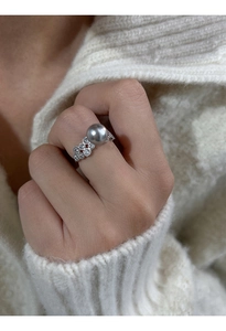 Close-up of a sterling silver ring with a large grey pearl and sparkling zircon accents