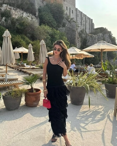 Détail d'une robe noire sans manches en maille avec ourlet à franges multicouches à la plage