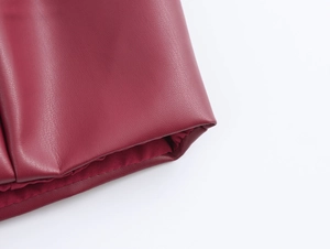 Vue détaillée de la texture du similicuir rouge et des finitions des bords surpiqués