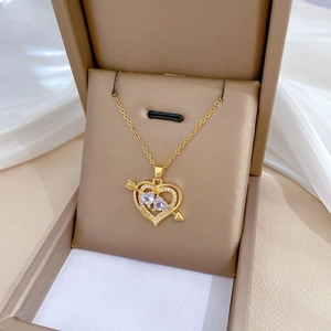 Close-up of gold titanium necklace with double heart-shaped crystals and zircon accents