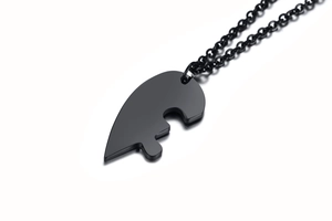 Macro shot of black titanium steel heart puzzle friendship pendant and matching chain