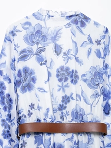 Détail de la robe midi blanche à imprimé floral bleu et ceinture en cuir marron