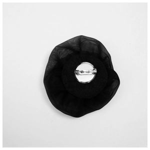 Close-up of black mesh flower brooch back with silver metal safety pin fastener