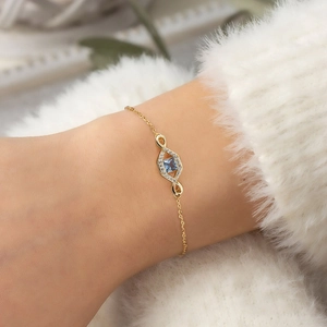 Detailed close-up of 18K gold plated silver bracelet with square blue gemstone on a wrist