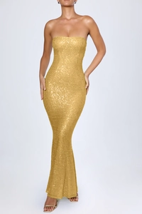 Detailed close-up of high-density golden sequins on a bodycon strapless mermaid maxi dress