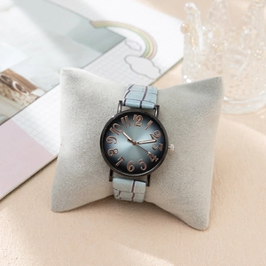 Vue détaillée d'une montre à cadran dégradé et chiffres arabes sur un coussin gris