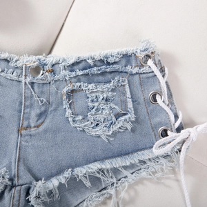 Dettaglio shorts in denim azzurro con lacci laterali e bordi sfrangiati alla moda