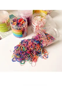 Close-up of colorful mini elastic hair bands in clear jars on a white surface
