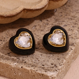 Gros plan de boucles d'oreilles cœur en plaqué or 18K avec émail noir et pierre facettée