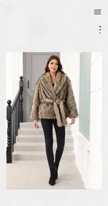 Detail of faux fur coat with waist belt and thick plush texture for winter style
