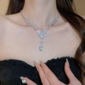Close-up of silver zircon butterfly necklace with waterdrop tassel on a model