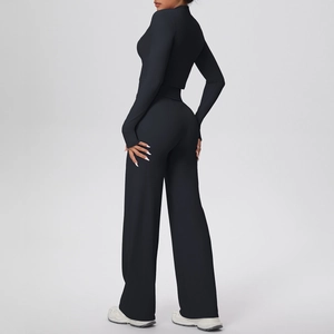 Detail view of black yoga set showing zipper top with thumb holes and wide leg pants