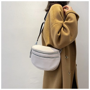 Detail of white litchi grain crescent crossbody bag with double zippers on model