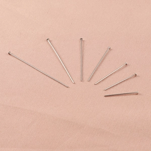 Flat head pins in various lengths for DIY jewelry making on pink fabric background