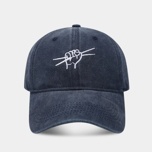 Close-up of fist embroidery detail on vintage washed denim baseball cap with fine stitching