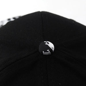 Macro view of detailed black twill fabric and camo pattern button on the baseball cap top