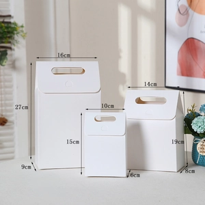 Three sizes of white minimalist kraft paper gift bags with handles for packaging