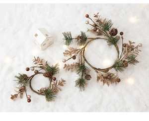Close-up of luxury pine cone Christmas wreaths with gold berries on a snowy background