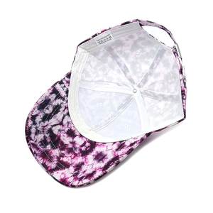 Inside view of purple tie-dye baseball cap showing 100% polyester lining and metal buckle