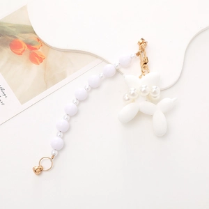 Detailed view of white pearl beaded chain with a cute balloon dog charm and gold metal clasp