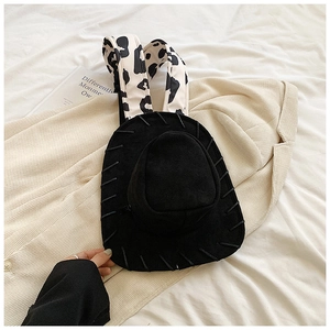 Detail of creative hat-shaped backpack with cow print straps and denim texture finish