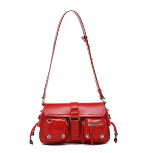 Detail of red faux leather shoulder bag with double zip pockets and silver hardware