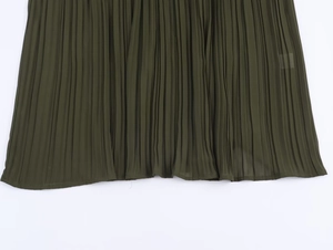 Detailed macro view of olive green pleated chiffon fabric hem on the midi dress