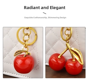 Detail of red cherry and apple resin pendants with gold leaf accents on a white bag