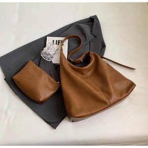 Flat lay of brown soft leather tote bag set with metal buckles and matching pouch