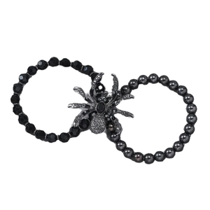 Gothic punk style black beaded bracelets with intricate metal spider charms on white background