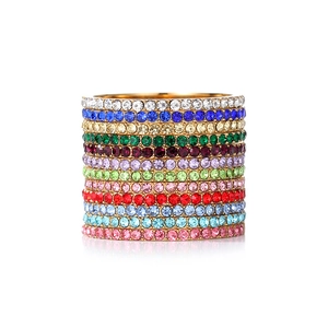 Macro shot of 11 colorful rhinestone-encrusted gold-tone stacking rings in vibrant hues