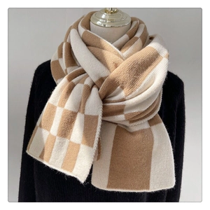 Close-up of a soft beige and white checkered knit scarf with elegant knot styling