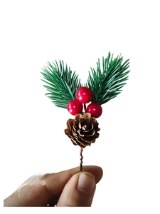 Detail of Christmas pick with red berries, pine cone and green needles on a wire stem