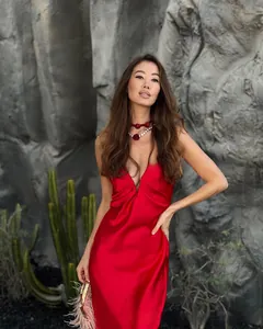 Detail of vibrant red satin midi dress featuring a deep V-neck and silky texture