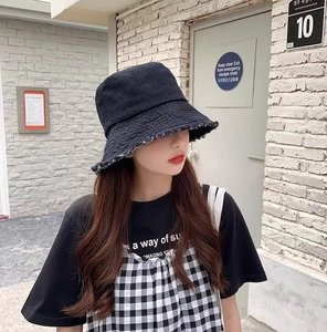 Photo de style de vie d'un chapeau bob en jean noir avec bords effilochés pour femmes
