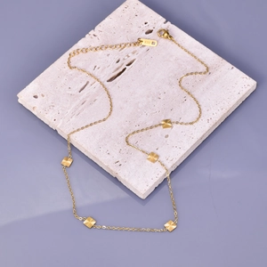 Detail showing 18K gold-plated textured square pendants and lobster clasp with K18 tag